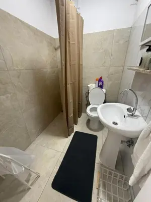 a bathroom with a white sink and a toilet at LivePro in Larnaka