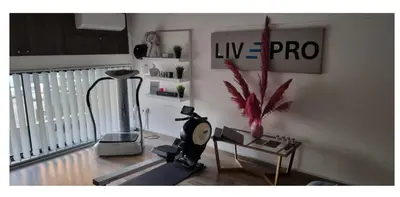 a living room with a treadmill and a table with a plant at LivePro in Larnaka