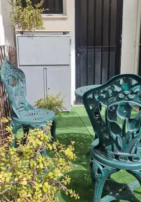 a green bench and a chair in a yard at LivePro in Larnaka