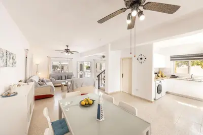 a living room with white furniture and a ceiling fan at Ayia Thekla Sea Breeze Villa in Ayia Napa