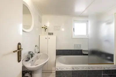a white bathroom with a sink and a tub at Ayia Thekla Sea Breeze Villa in Ayia Napa