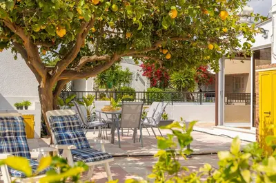 a table and chairs under an orange tree at Ayia Thekla Sea Breeze Villa in Ayia Napa