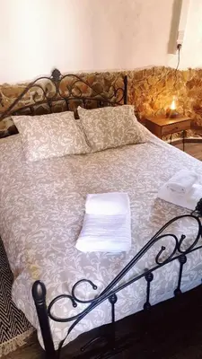 a bedroom with a bed with a white comforter at Traditional adobe house in Evrychou with cozy garden and fireplace! in Nicosia