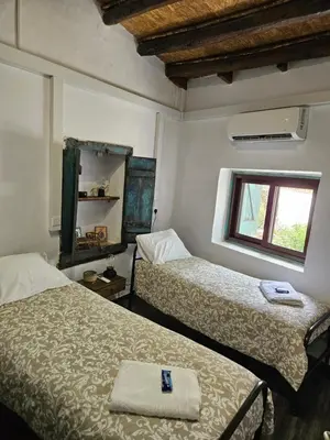 a room with two beds and a window in it at Traditional adobe house in Evrychou with cozy garden and fireplace! in Nicosia