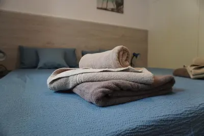 a pile of towels sitting on top of a bed at Skeleas Apartments in Pissouri