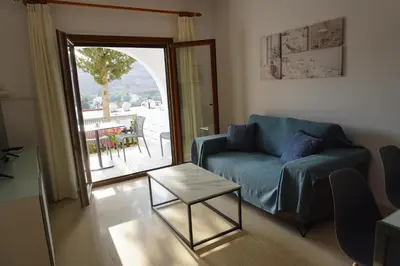 a living room with a blue couch and a table at Skeleas Apartments in Pissouri