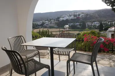 a table and four chairs on a balcony with a view at Skeleas Apartments in Pissouri