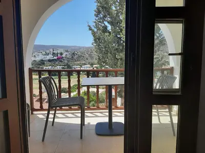 a table and chairs on a balcony with a view at Skeleas Apartments in Pissouri
