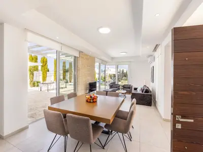 a dining room with a wooden table and chairs at Villa Natalie-Mylos H24 in Protaras