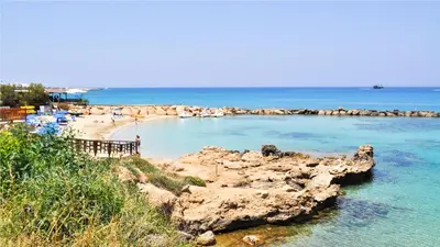 a beach with a bunch of rocks in the water at Protaras Holiday Villa 045 in Protaras