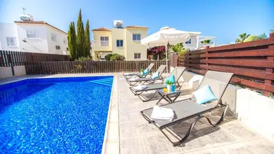 a swimming pool with chairs and an umbrella and a house at Ayia Napa Holiday Villa 040 in Ayia Napa