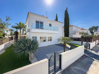 a white house with a fence and palm trees at Ayia Napa Holiday Villa 040 in Ayia Napa