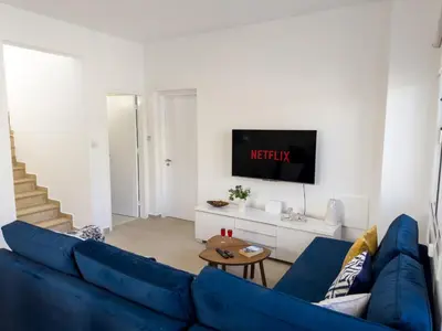 a living room with a blue couch and a tv at Ayia Napa Holiday Villa 040 in Ayia Napa