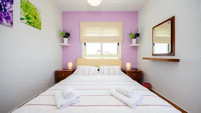 a bedroom with a large bed with two white towels at Ayia Napa Holiday Villa 036 in Ayia Napa