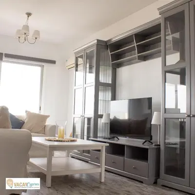 a living room with a tv and a table at Downtown Larnaca Apartment in Larnaka