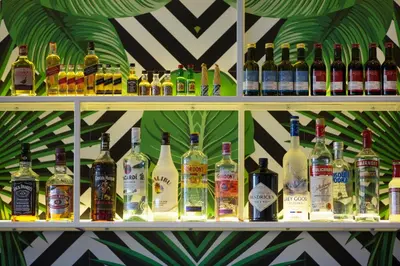 a shelf filled with lots of bottles of alcohol at Harmony Bay Hotel in Limassol