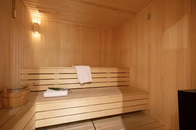 a sauna with a wooden bench with a towel at Harmony Bay Hotel in Limassol