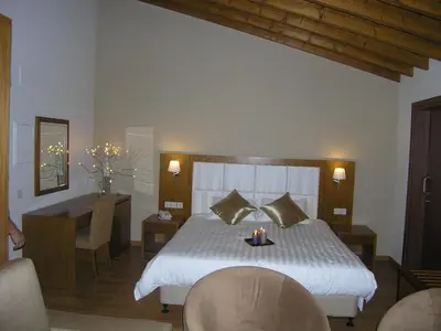 a bedroom with a bed and a table with candles on it at Livadia Hotel Kyperounta in Kyperounda