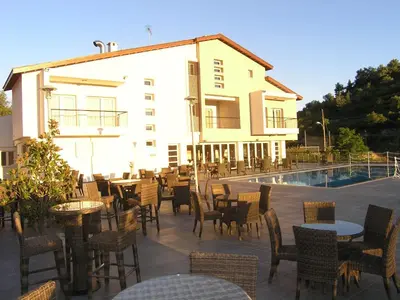 a patio with tables and chairs next to a building at Livadia Hotel Kyperounta in Kyperounda