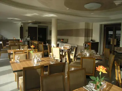 a restaurant with wooden tables and chairs with flowers on them at Livadia Hotel Kyperounta in Kyperounda