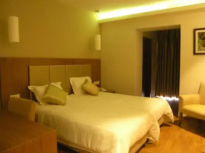 a bedroom with a large white bed and a chair at Livadia Hotel Kyperounta in Kyperounda