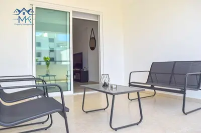 a living room with two chairs and a table at SeaWitch Apartment in Larnaka