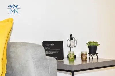 a living room with a couch and a table with a chair at SeaWitch Apartment in Larnaka