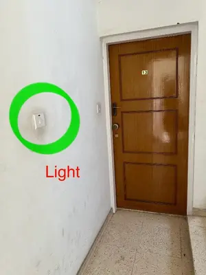 a door in a room with a light sign on the wall at Marethea rooms in Larnaka