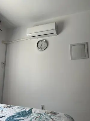 a clock on a wall next to a bed at Marethea rooms in Larnaka