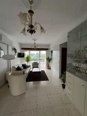 a living room with a couch and a chandelier at Marethea rooms in Larnaka