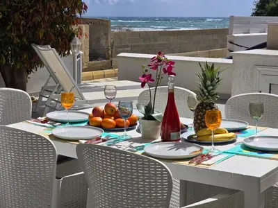 a white table with fruit and wine glasses at Sandy Coast Beach Villa in Larnaka