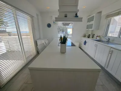a kitchen with a white counter with a vase on it at Sandy Coast Beach Villa in Larnaka