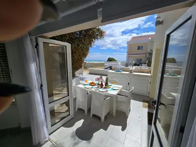 an open door to a patio with a table and chairs at Sandy Coast Beach Villa in Larnaka
