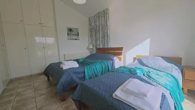 two beds in a bedroom with blue sheets and towels at STAY Princess Villa in Protaras