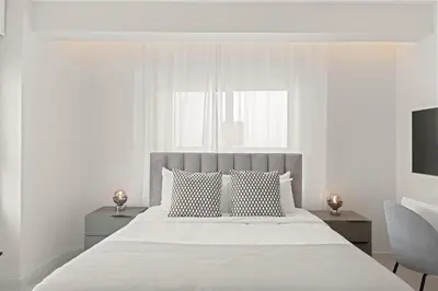 a white bedroom with a large bed with two pillows at Phaedrus Living: Limassol Seaside Residences 05 in Limassol