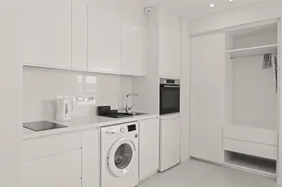 a white kitchen with a washing machine in it at Phaedrus Living: Limassol Seaside Residences 05 in Limassol