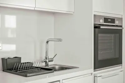 a white kitchen with a sink and a stove at Phaedrus Living: Limassol Seaside Residences 05 in Limassol