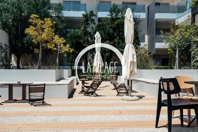 a group of chairs and umbrellas in front of a sign at NEW 2BR Townhouse in Luxury Resort Pool & Beach in Protaras