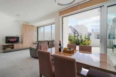 a dining room with a table and chairs at NEW 2BR Townhouse in Luxury Resort Pool & Beach in Protaras