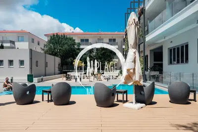 a pool with tables and chairs and an umbrella at NEW 2BR Townhouse in Luxury Resort Pool & Beach in Protaras