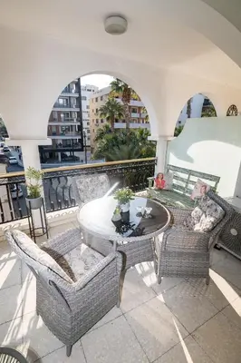 a patio with a table and chairs on a balcony at Quattro City Center Apartments in Larnaka