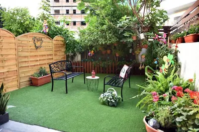 a garden with two chairs and a table and some plants at Quattro City Center Apartments in Larnaka