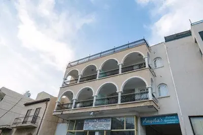 a building with a balcony on the side of it at Quattro City Center Apartments in Larnaka