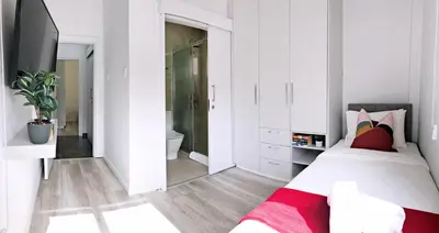 a white bedroom with a bed and a tv at Luxury Stay at Mackenzie Beach with Private Parking and Balcony in Larnaka