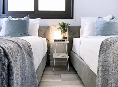 two beds next to each other with a nightstand between them at Luxury Stay at Mackenzie Beach with Private Parking and Balcony in Larnaka