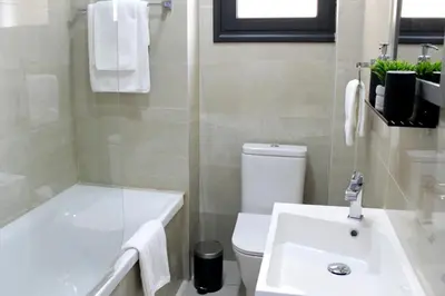 a bathroom with a white tub and a toilet and a sink at Luxury Stay at Mackenzie Beach with Private Parking and Balcony in Larnaka