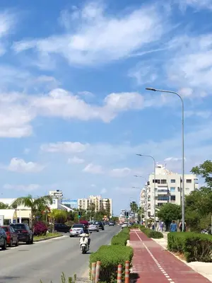 a street with cars parked on the side of the road at Luxury Stay at Mackenzie Beach with Private Parking and Balcony in Larnaka