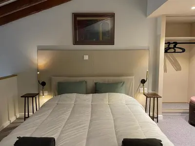 a bedroom with a large white bed with two tables at Calming Mountain View Apt with Balcony & Free Parking near Kakopetria in Nicosia
