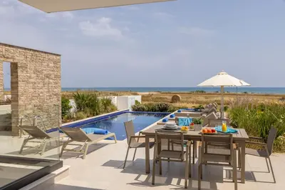 a patio with a table and chairs and a swimming pool at Villa Pliades in Ayia Napa