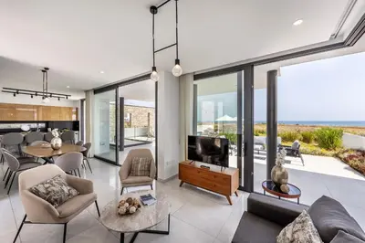 a living room with a couch and a tv at Villa Pliades in Ayia Napa